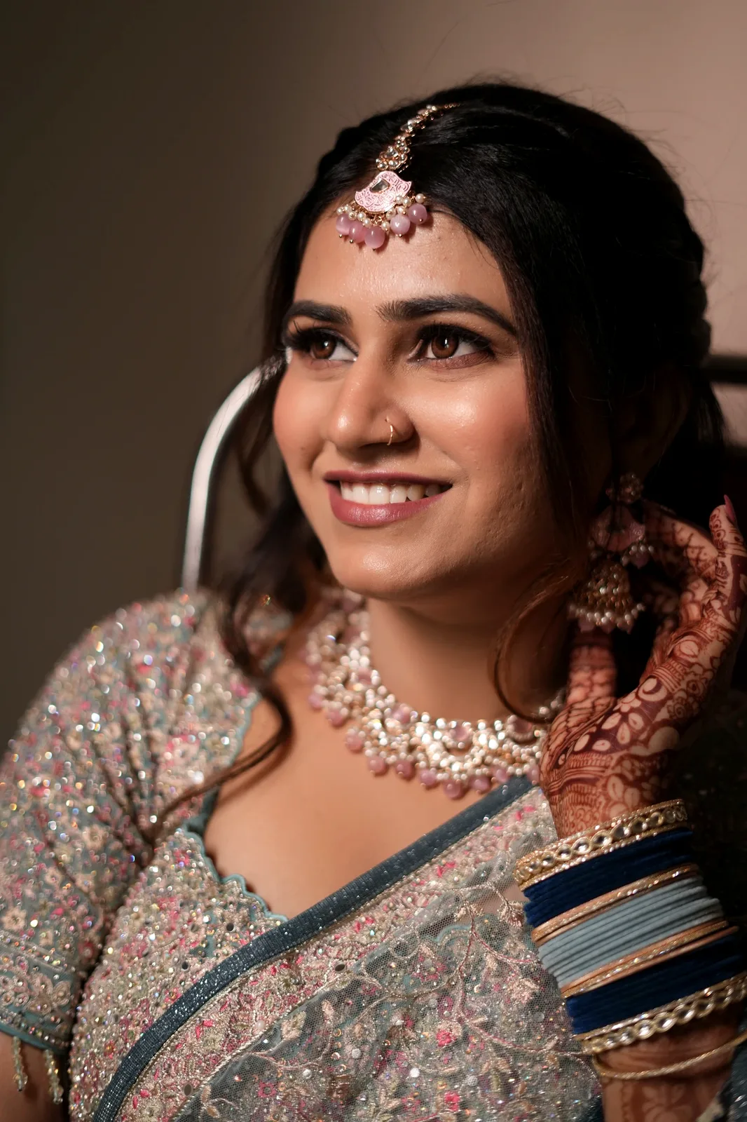 Candid bridal portrait — mehendi and pastel lehenga